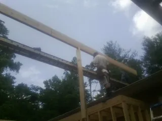 Carpenter setting a ridge beam over a new addition frame — Ice Dam Removal by Roofing Brothers in Volin