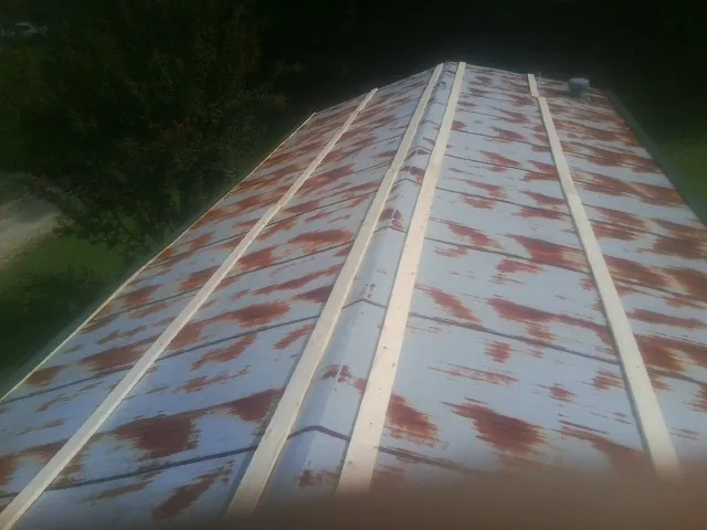 Rusted metal roof panels with new wood purlins before replacement — Storm Damage Roof Repair in Volin by Roofing Brothers