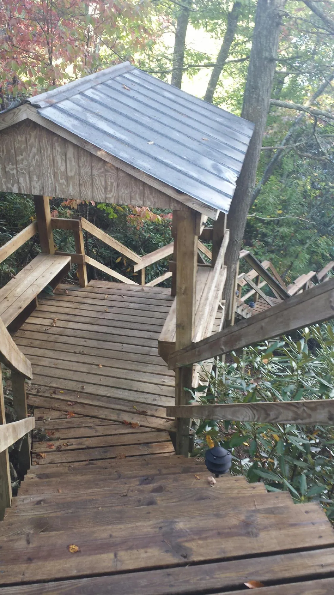 Metal roofed shelter over wooden steps on a wooded walkway — Skylight Repair & Installation work by our crew in Volin