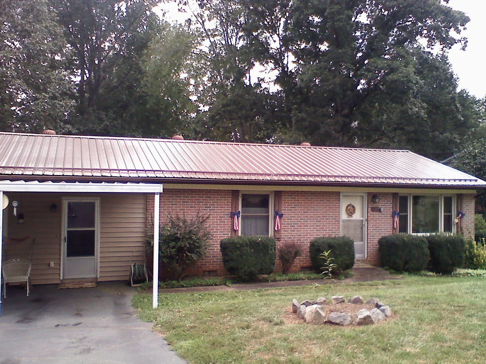Bronze metal roof and carport on a brick ranch home — Roof Repair work by our crew in Volin